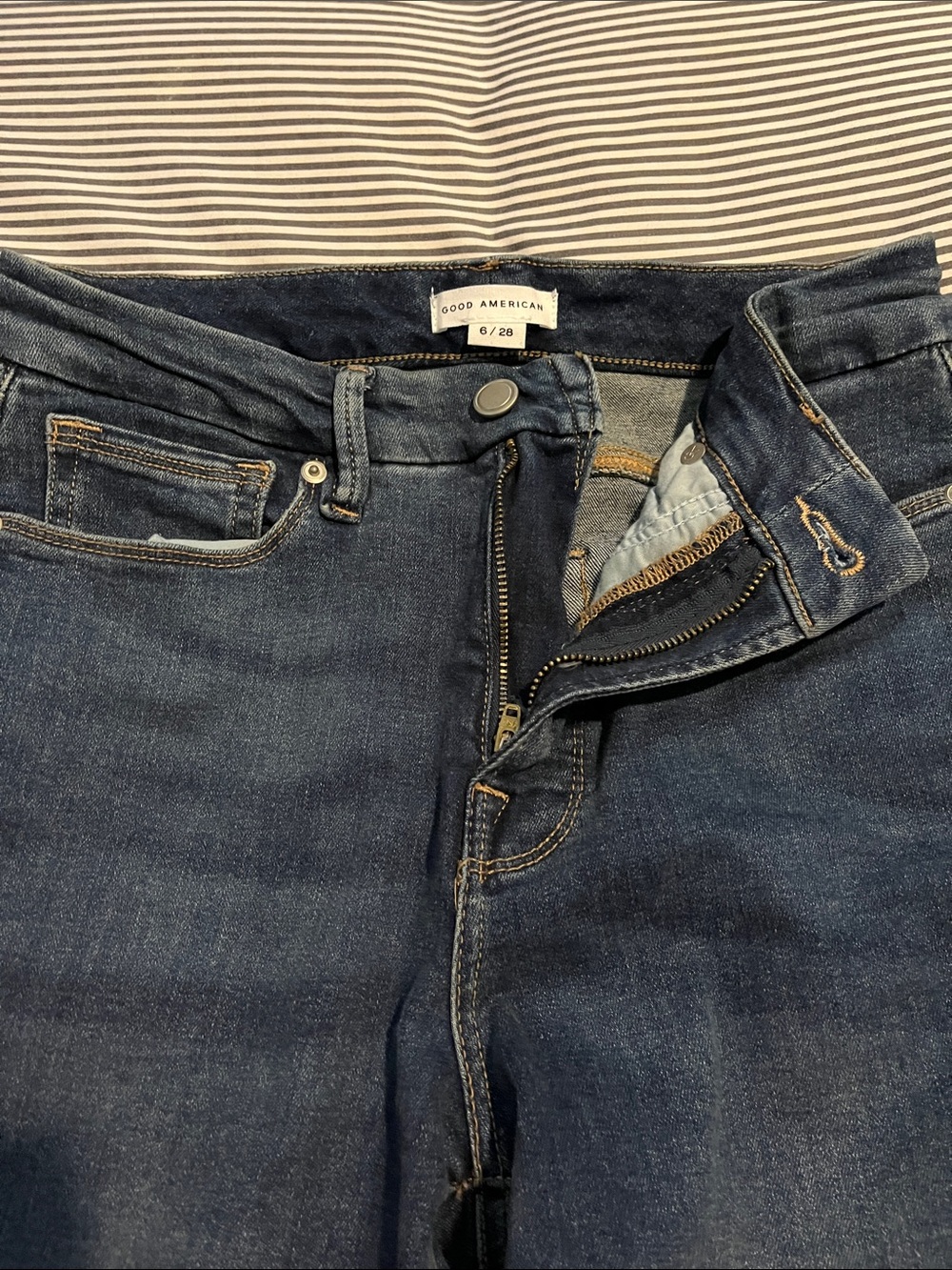 Good American cropped jeans with small slit at knee level
